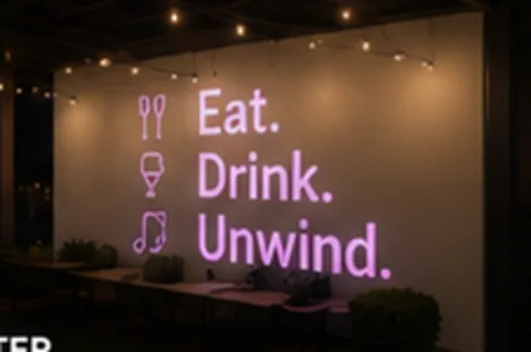 Eat. Drink. Unwind. projected on the wall in light