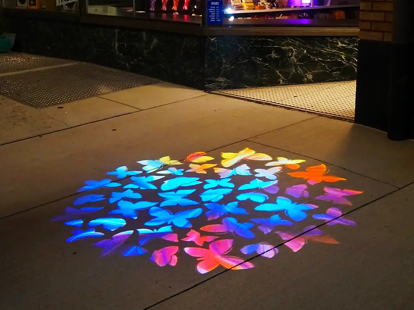 A welcome mat of light on the sidewalk — pull people in