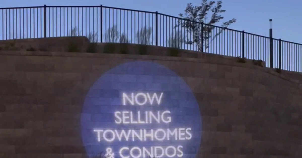 Aire community wordmark projected at the HHHunt apartment community entrance