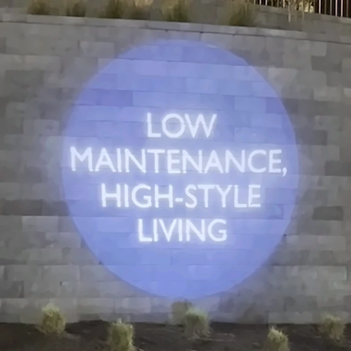 Low Maintenance, High-Style Living projected on The Aire's stone entrance wall at night
