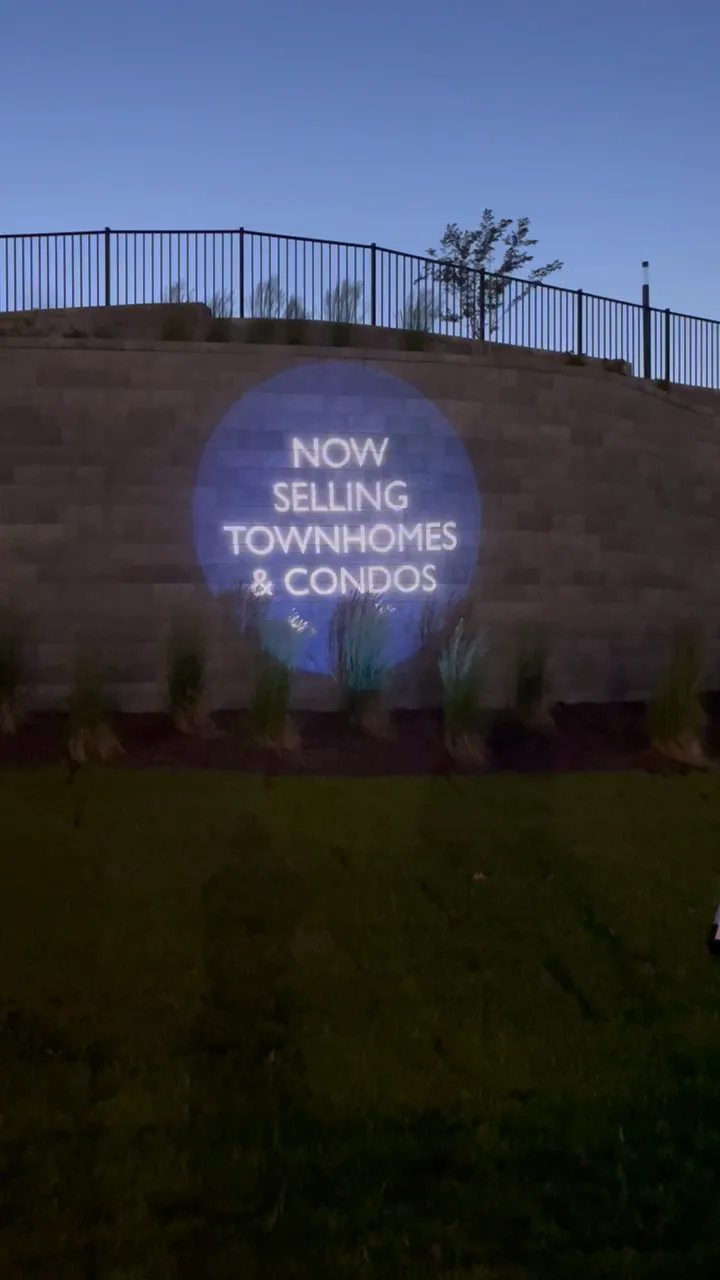 Now Selling message projected at the entrance of the HHHunt Aire community