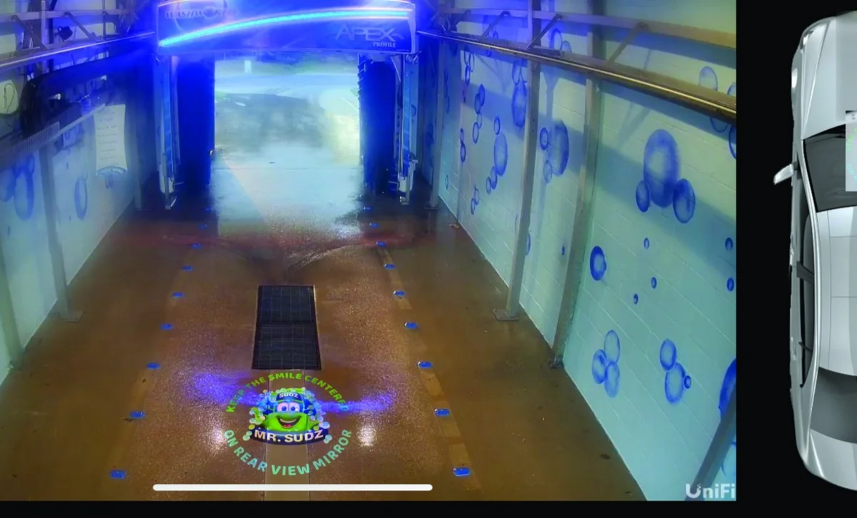 Branded car-wash tunnel interior — Infinity gobo logo projection