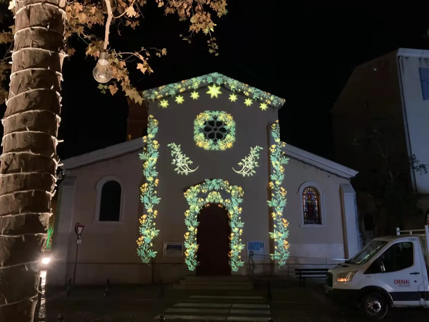 Floral garland and star gobos framing a chapel doorway at night