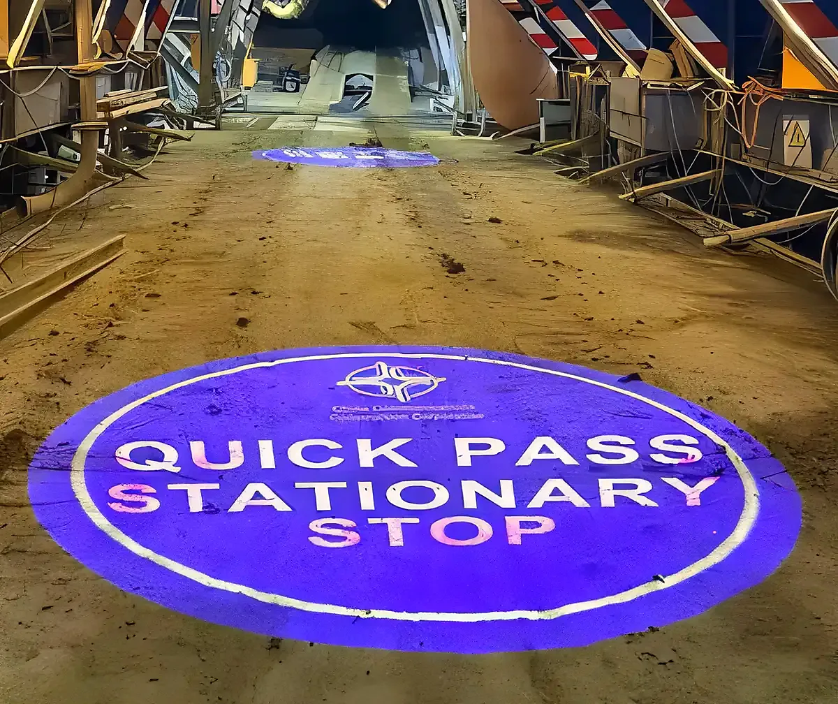 QUICK PASS STATIONARY STOP safety sign projected on a construction site floor