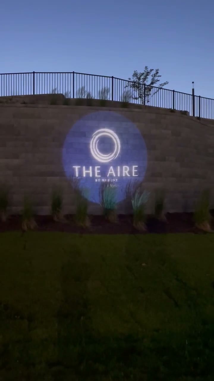 A real client logo lighting a property wall at dusk